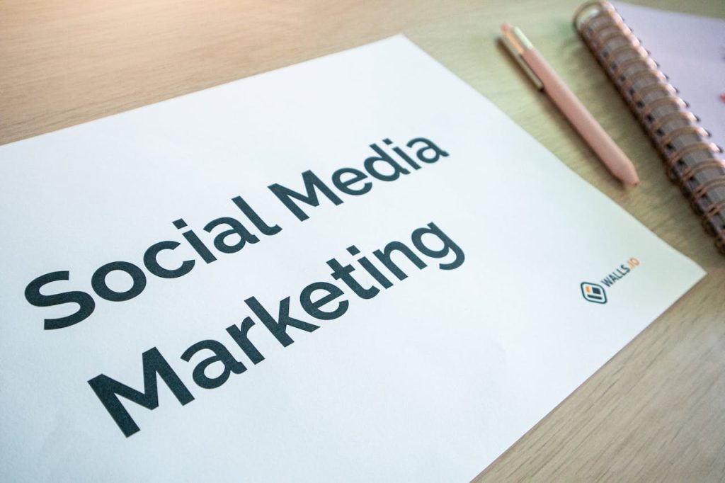 Gros plan d’un document intitulé « Social Media Marketing » avec un stylo et un carnet sur une table en bois, idéal pour introduire l’automatisation marketing.