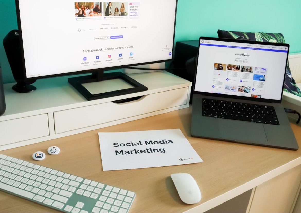 Un bureau moderne avec un ordinateur, un ordinateur portable affichant une plateforme de curation et une feuille "Social Media Marketing", illustrant l'utilisation de logiciels content marketing IA.