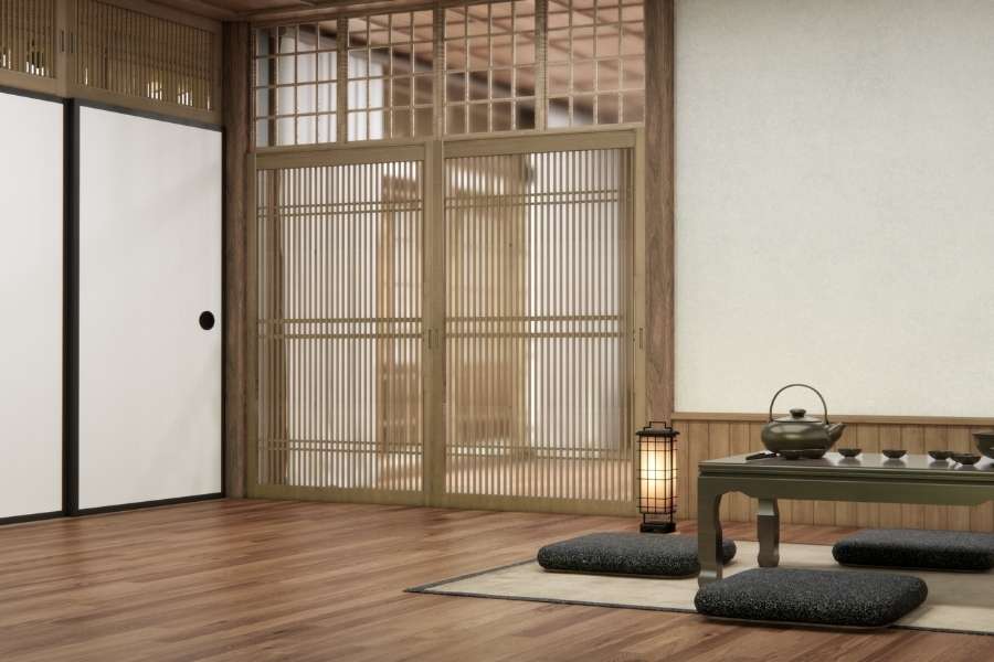 Une chambre zen de style traditionnel japonais avec un sol en bois et des cloisons coulissantes Shoji.