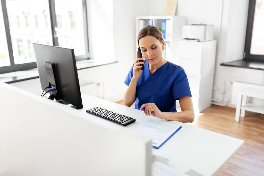 Un médecin de garde répond au téléphone à son bureau.