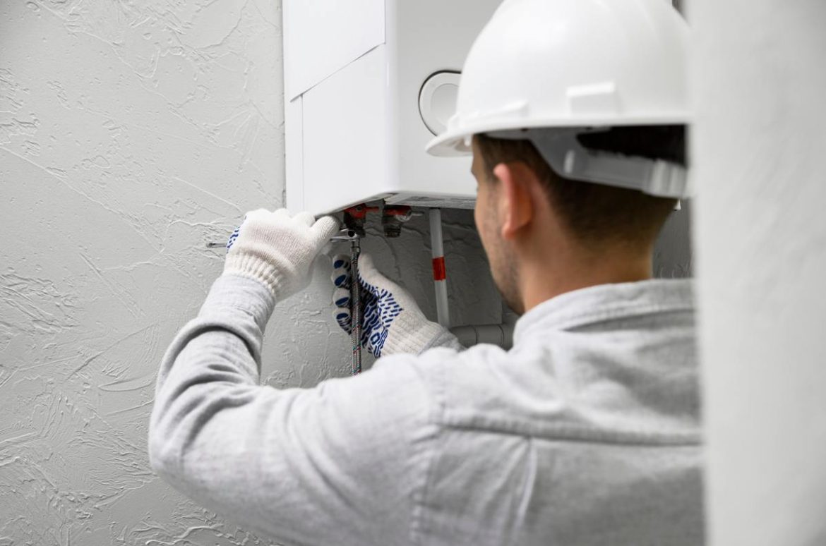 Un technicien en casque de chantier intervient sur une installation pour écarter les risques monoxyde de carbone chauffage